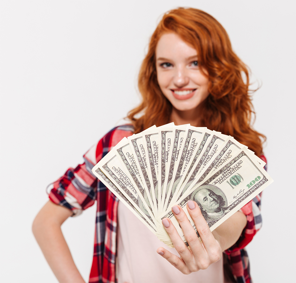 cheerful-pretty-young-redhead-lady-holding-money-cropped